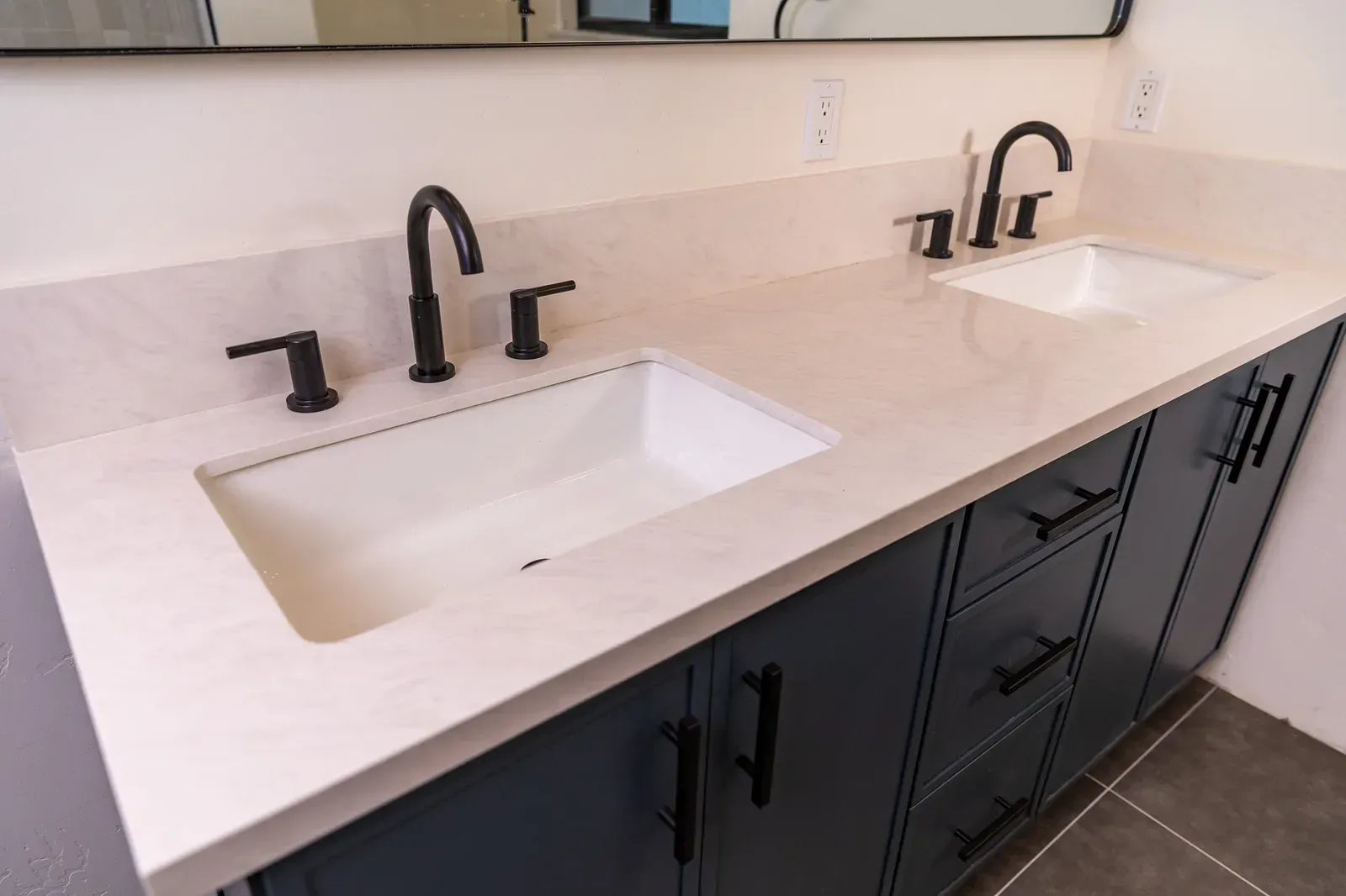 Modern bathroom vanity with two rectangular sinks, matte black faucets, and dark cabinets