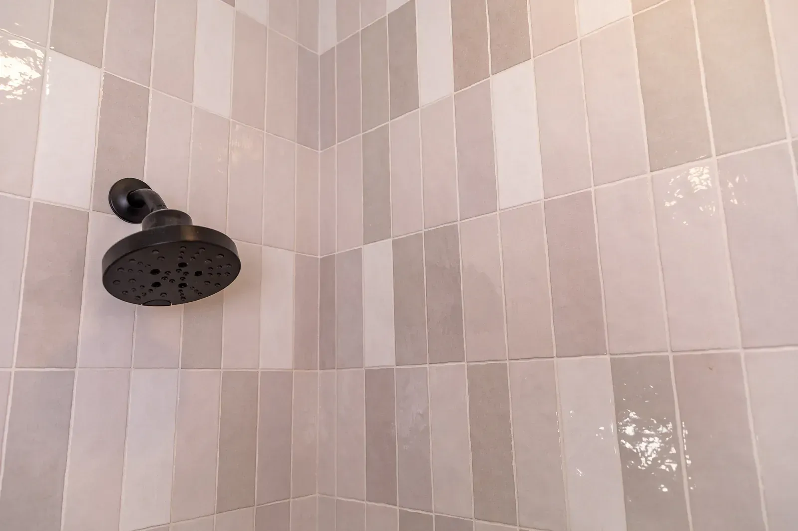 Black showerhead in a tiled bathroom shower corner