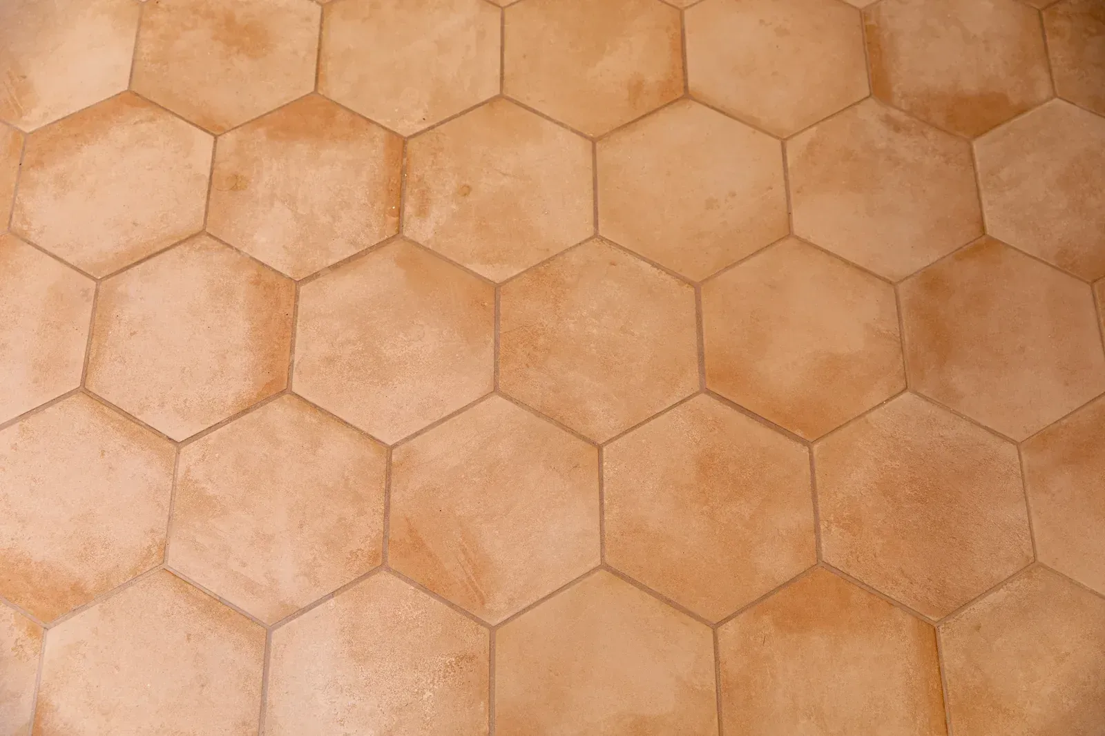 Tan hexagonal stone tiles in a repeating honeycomb pattern