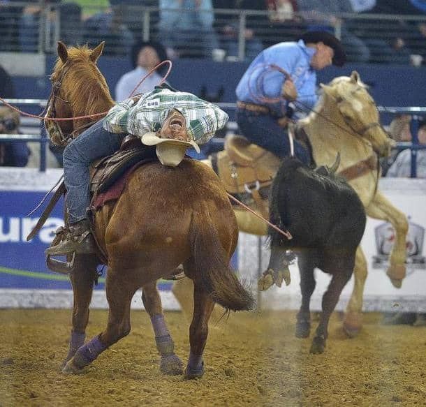 A man is riding a horse while another man rides a bull