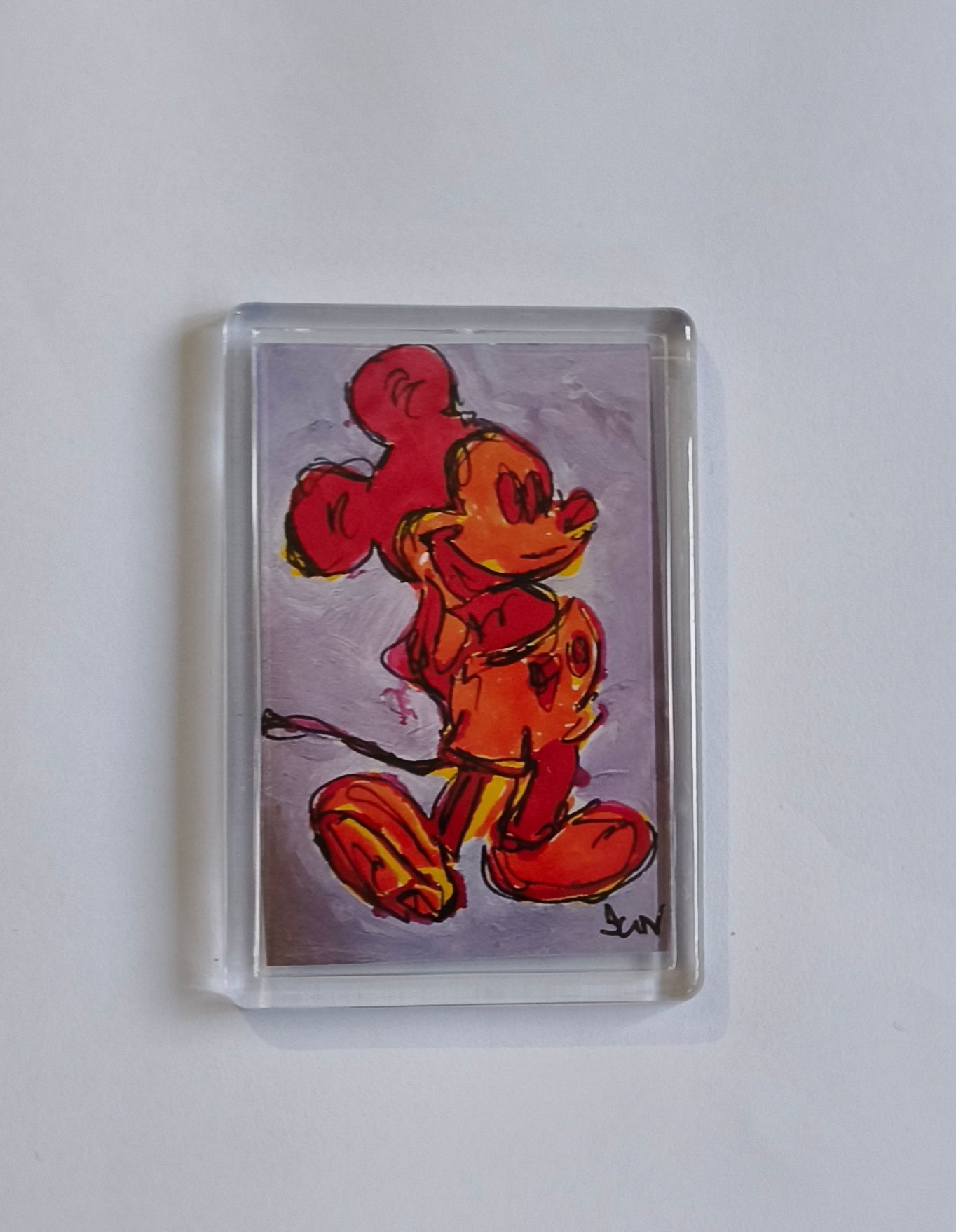 Een gestileerde, expressieve koelkast magneet van Mickey Mouse in oranje en rode tinten.