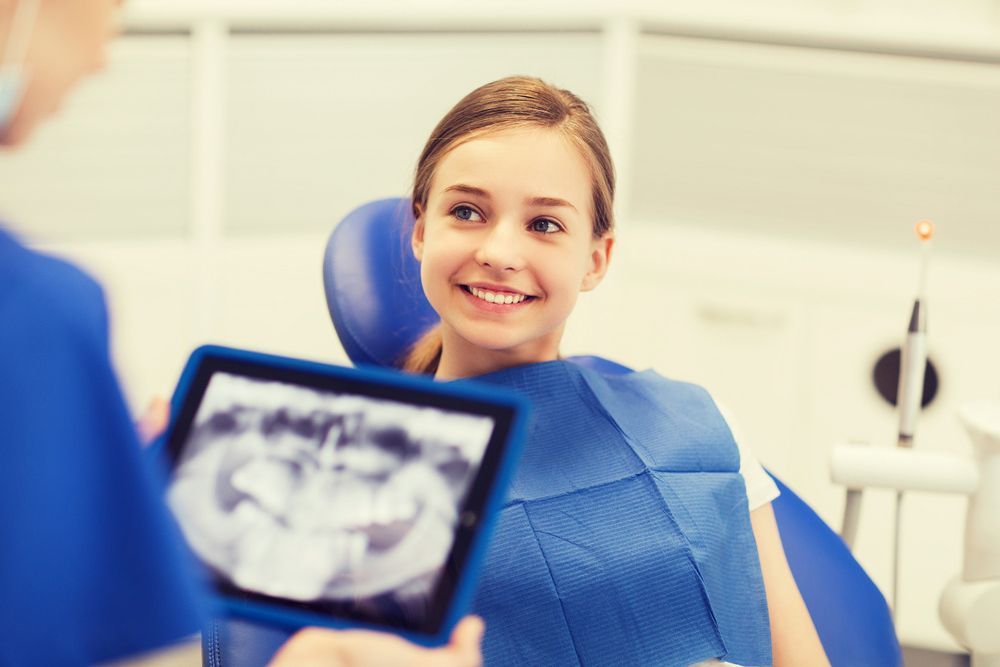 Dentist With X-Ray On Tablet And Patient — Dental Services in Berserker, QLD