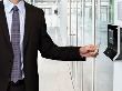 Man in suit uses keycard to access a building.