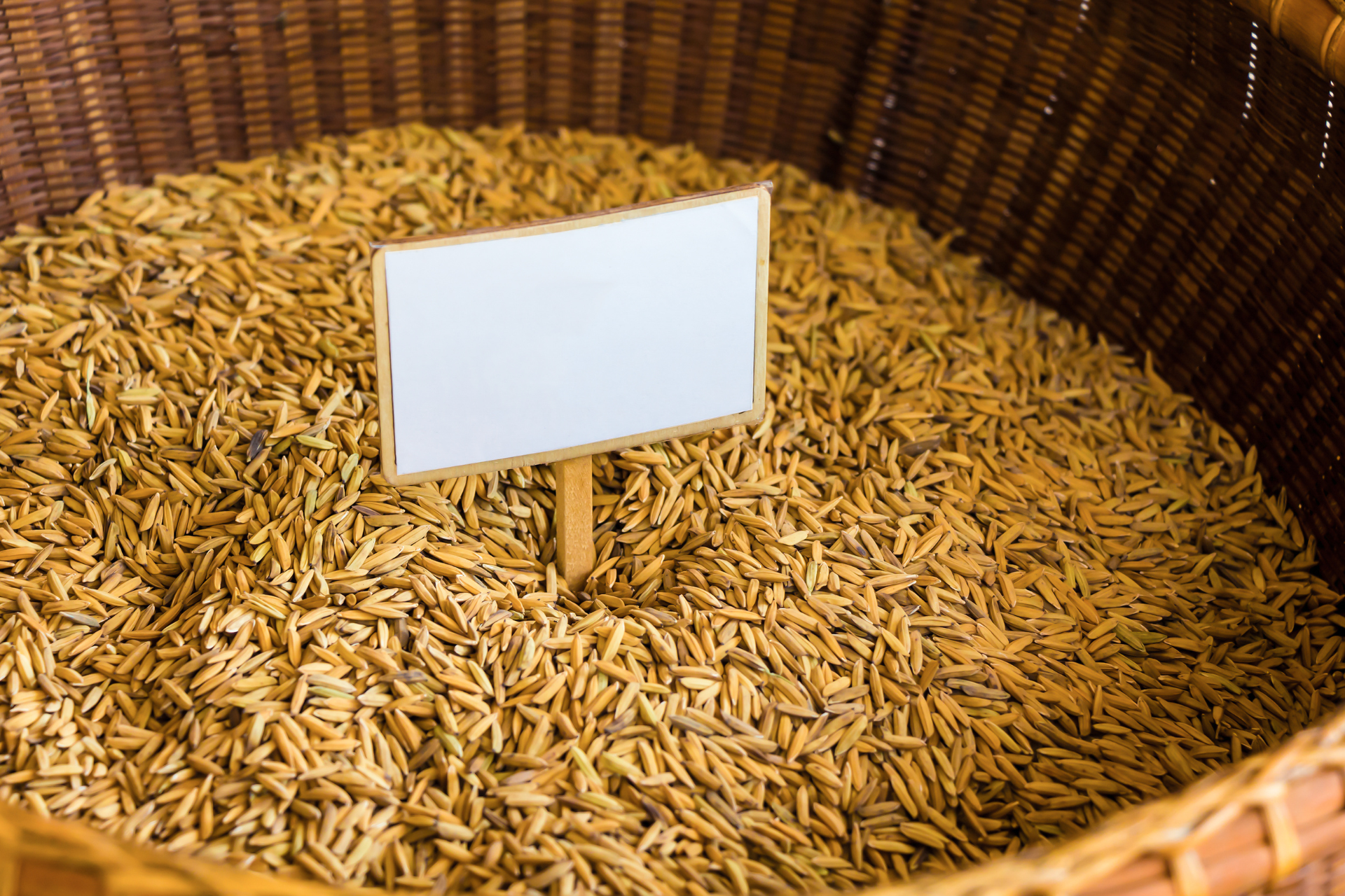 White sign stuck in a woven basket filled with dried grain husks