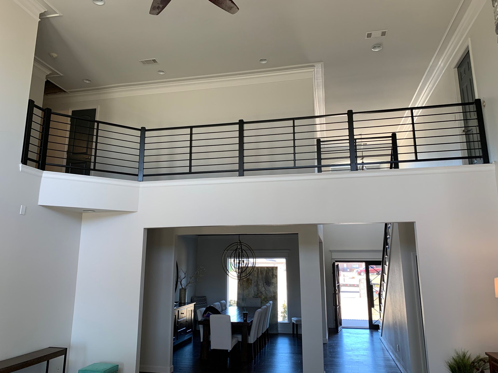 Interior view of a two-story home with a mezzanine overlooking the dining area.