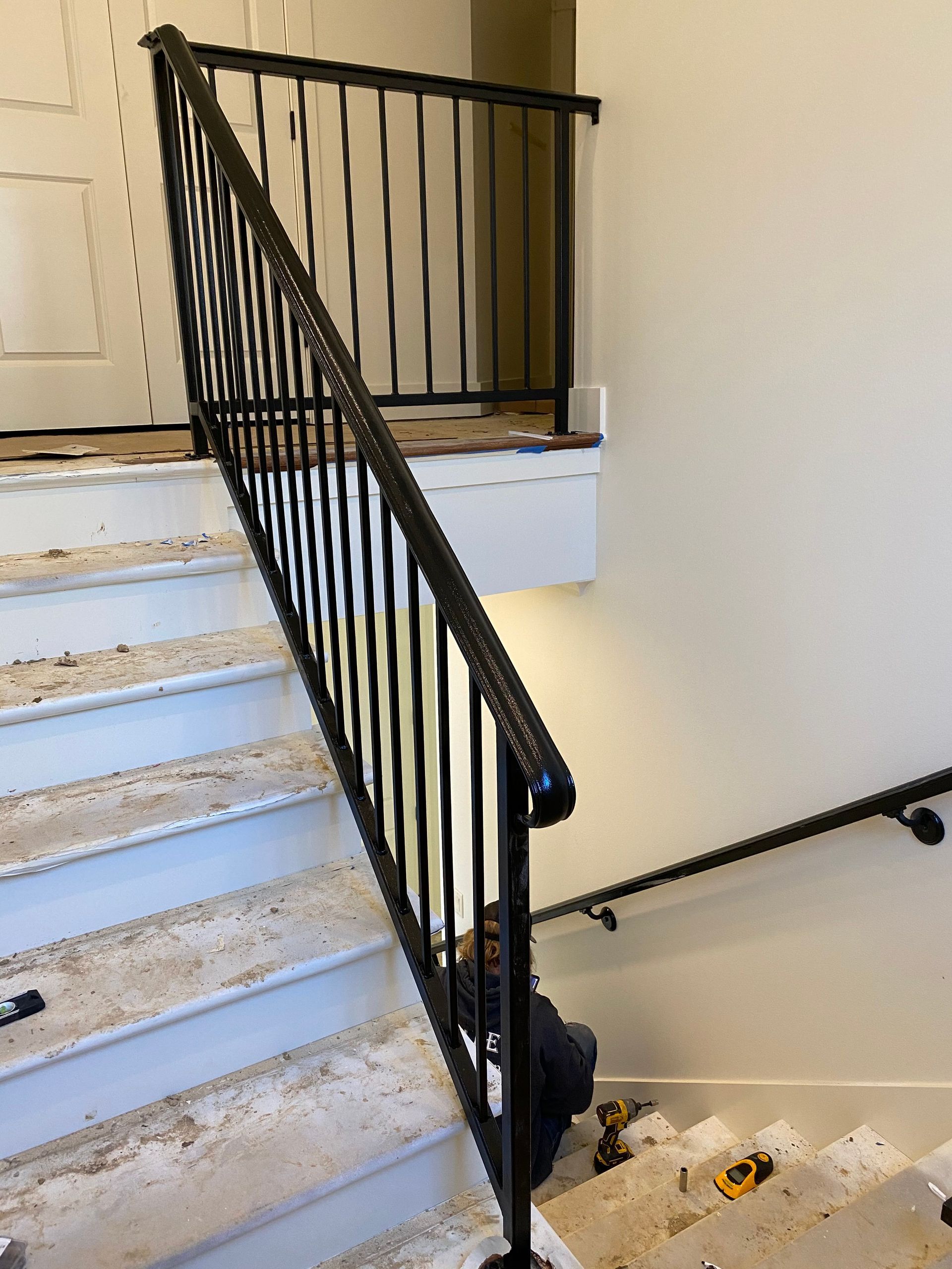 Black metal staircase handrail with vertical bars. Interior, stairs.