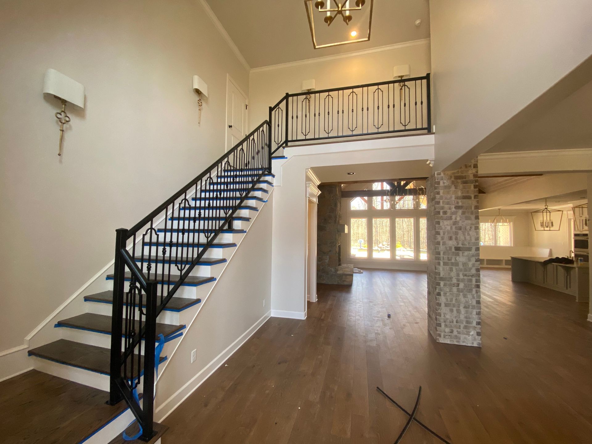 Interior of a home with a staircase, black railing, and hardwood floors.