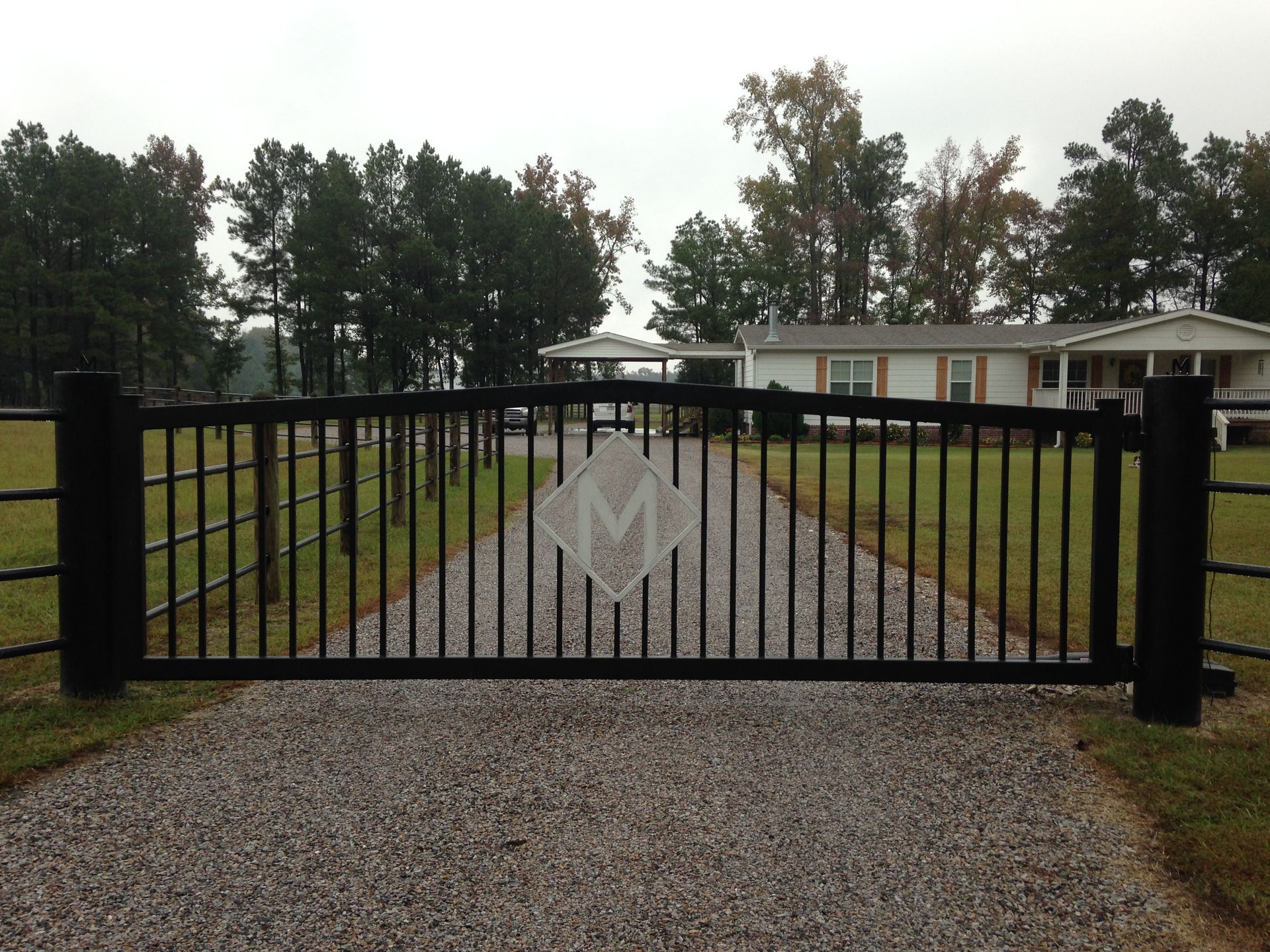 Black iron gate with diamond-shaped emblem and 