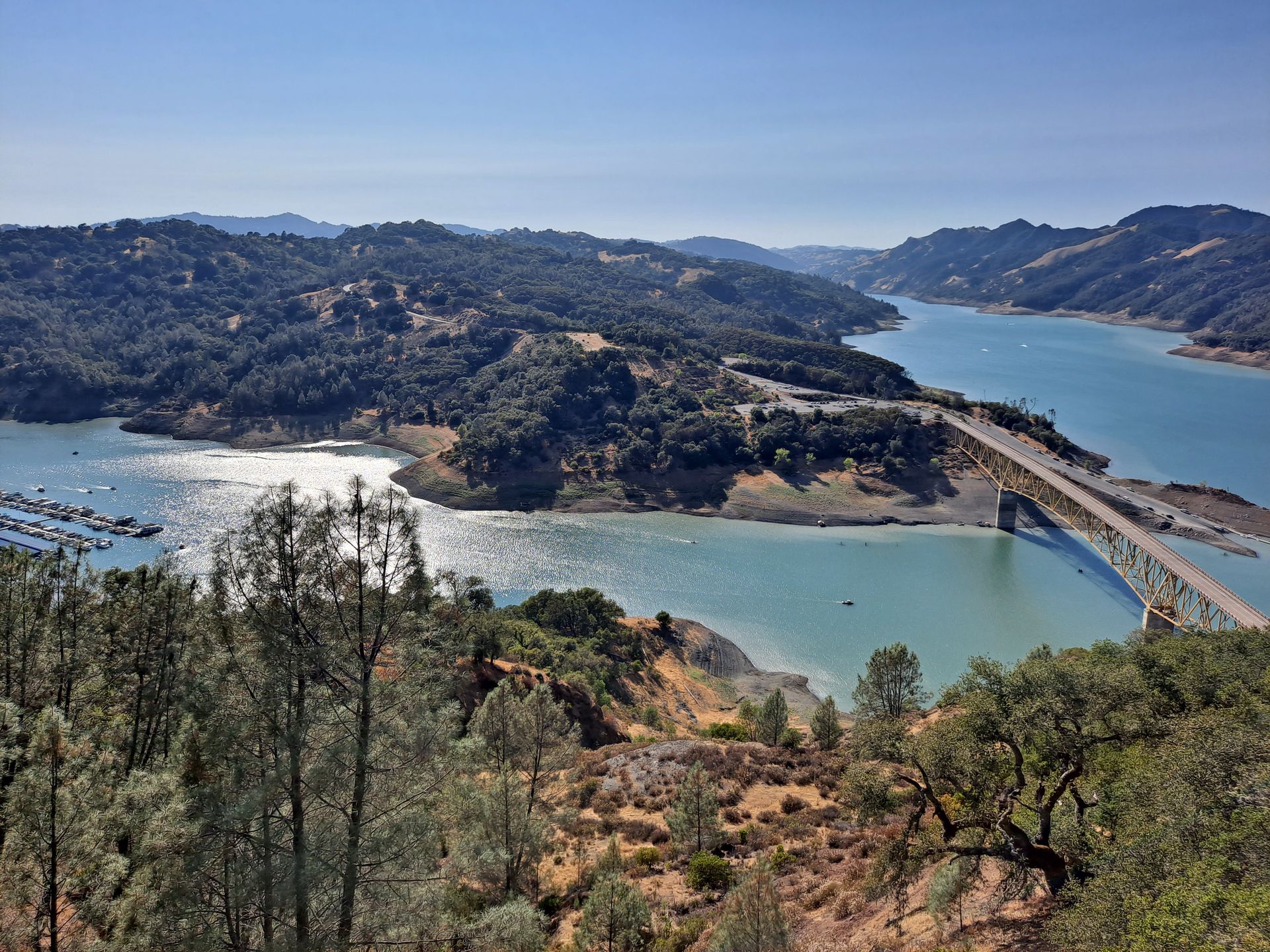 A bridge over a lake surrounded by trees and mountains