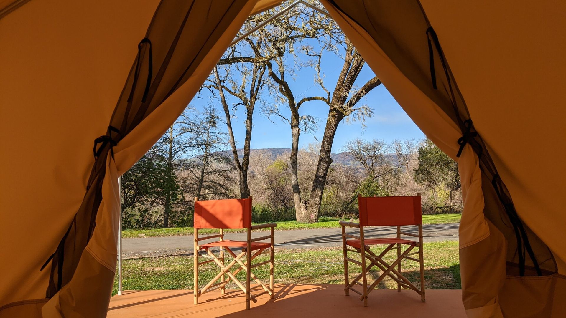A tent with two folding chairs inside of it