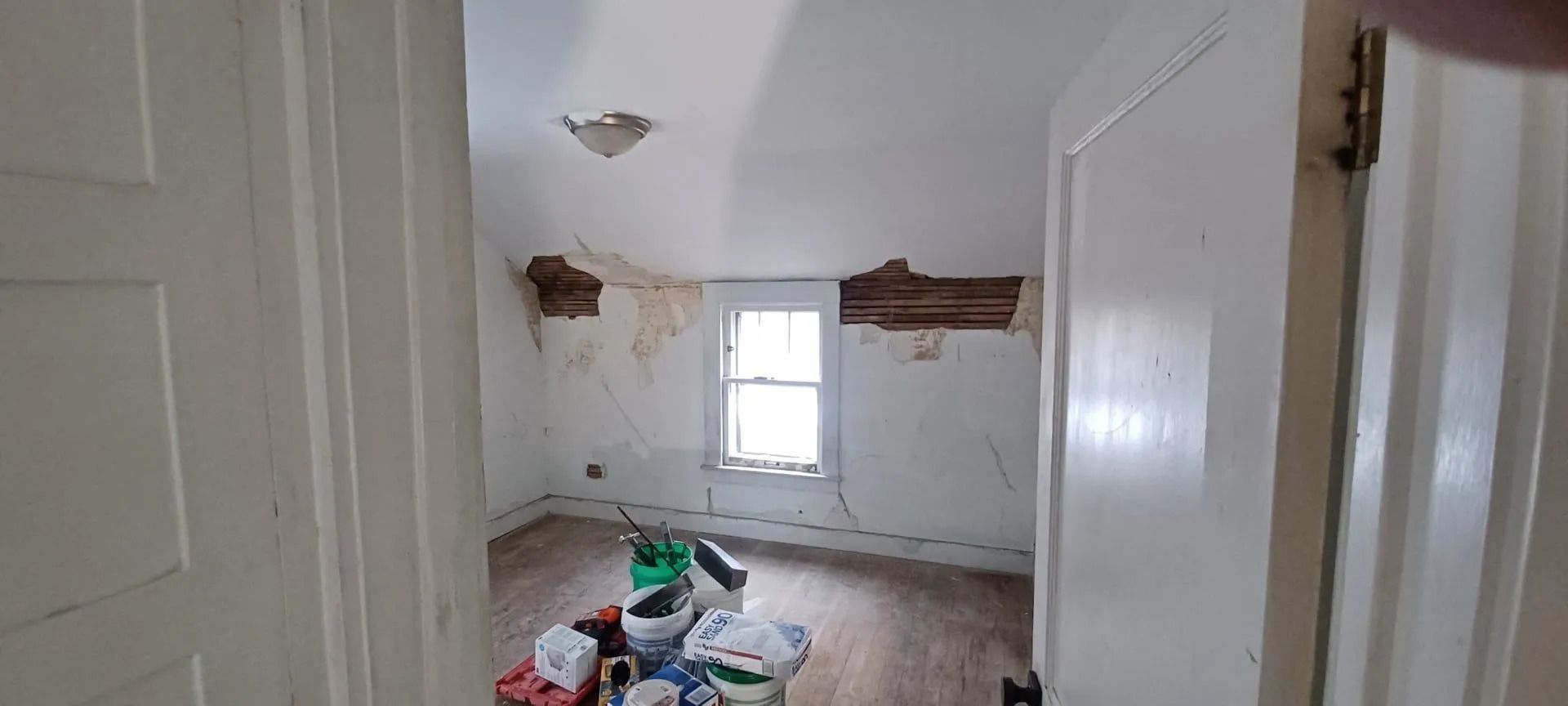 A room with a hole in the wall and a window.
