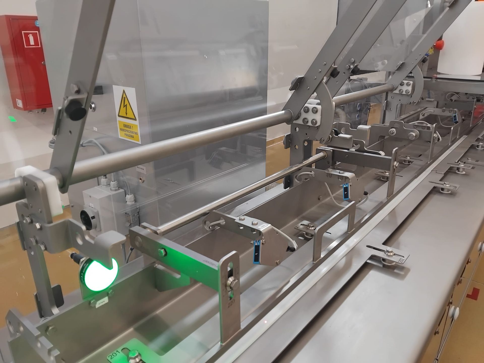Hinged safety enclosure with tempered glass for precision conveyor systems – durable and transparent design.