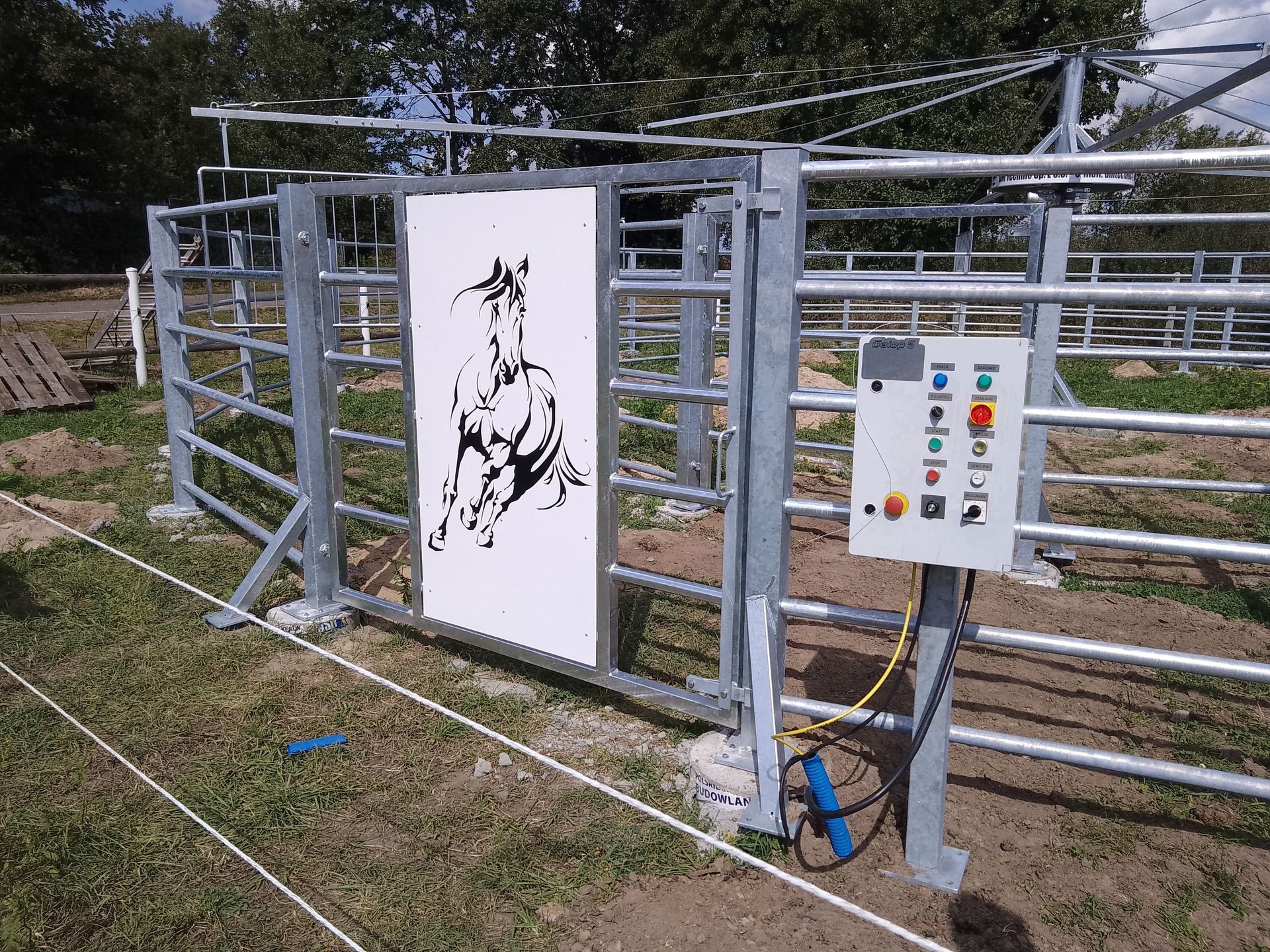 Galvanized horse walker fencing with control panel and decorative horse graphic – designed for stable operation and user-friendly control.