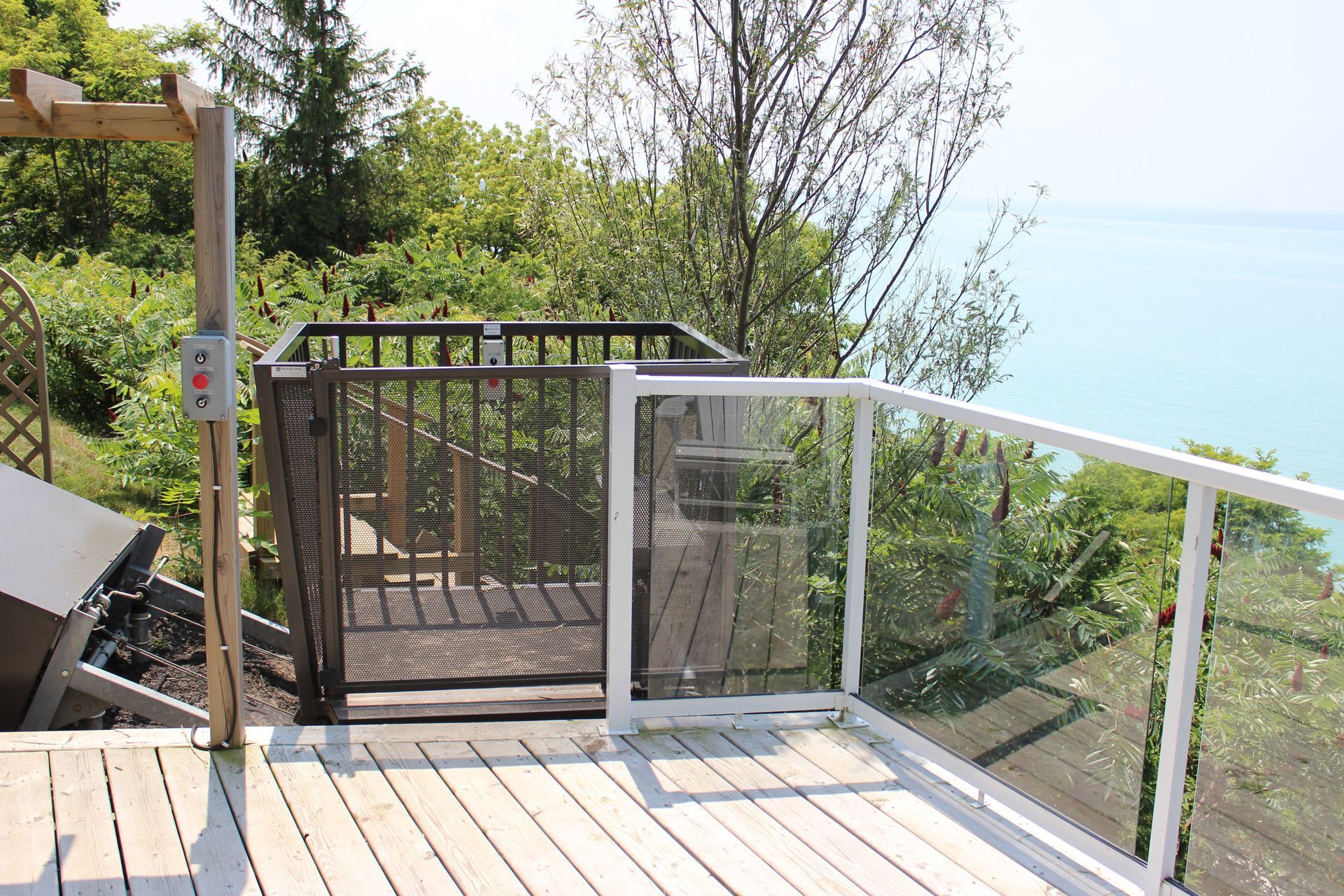 A wooden deck with a fence and a view of the ocean.