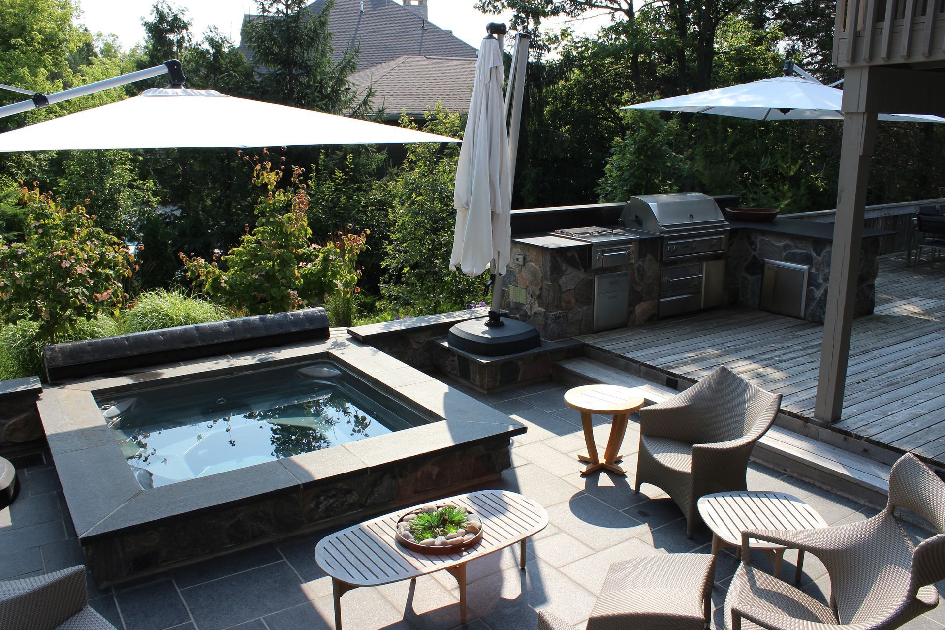 A patio area with a hot tub and umbrellas