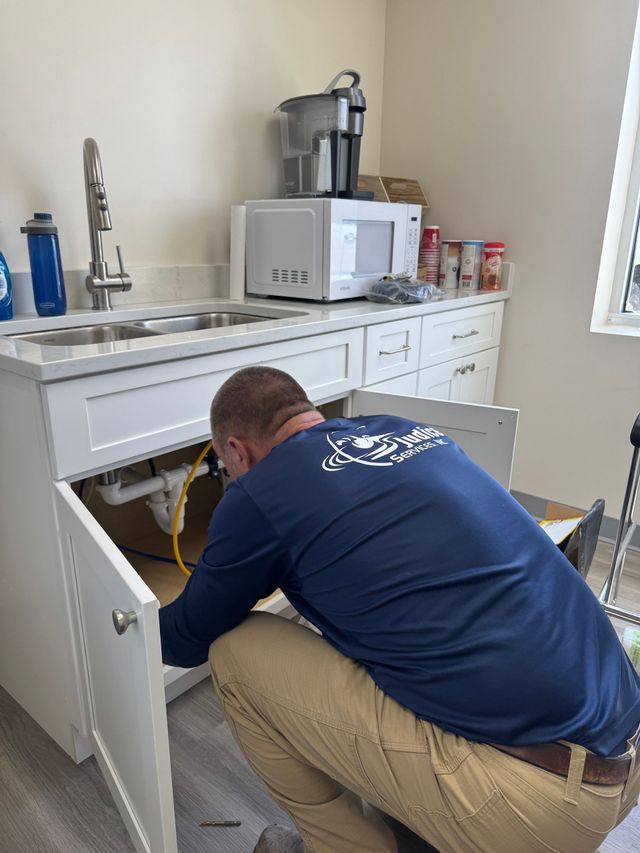 Plumber working with plumbing tools in a bathroom.