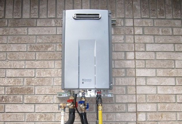 Tankless water heater mounted on a brick wall with connected pipes.