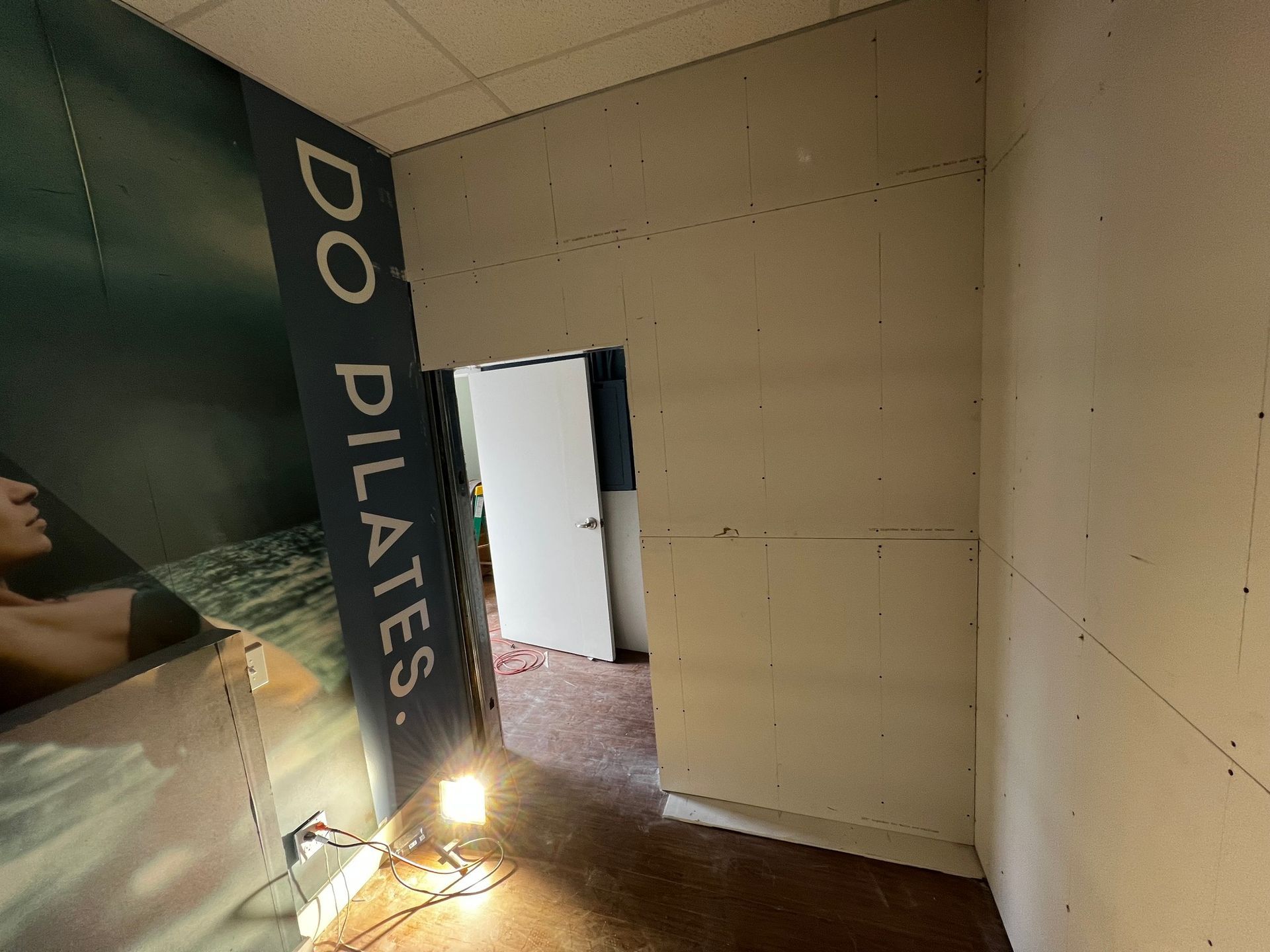 Interior view of a construction site featuring a doorway, raw drywall, a 