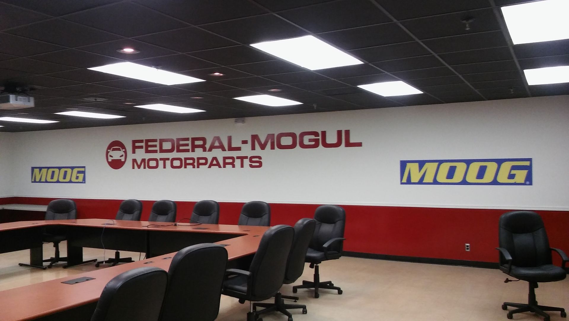 A conference room with federal mogul motorparts written on the wall