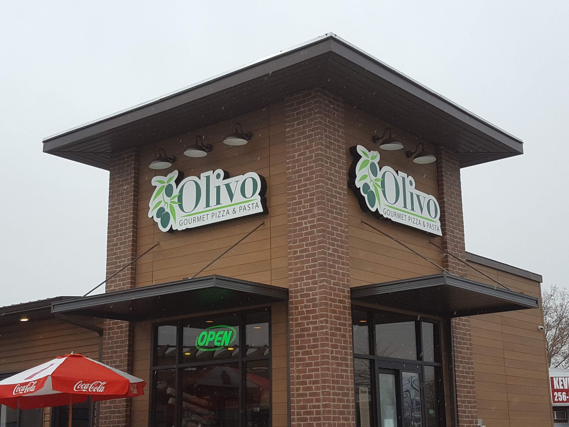 A brick building with a sign that says ' olivo ' on it