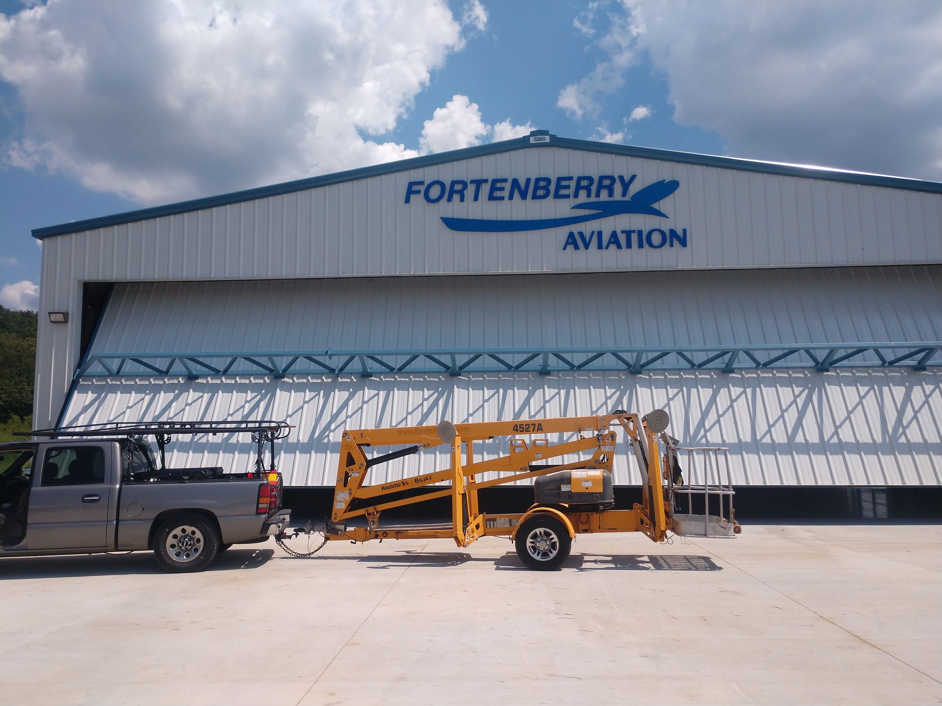 A truck is parked in front of a fortenberry aviation building