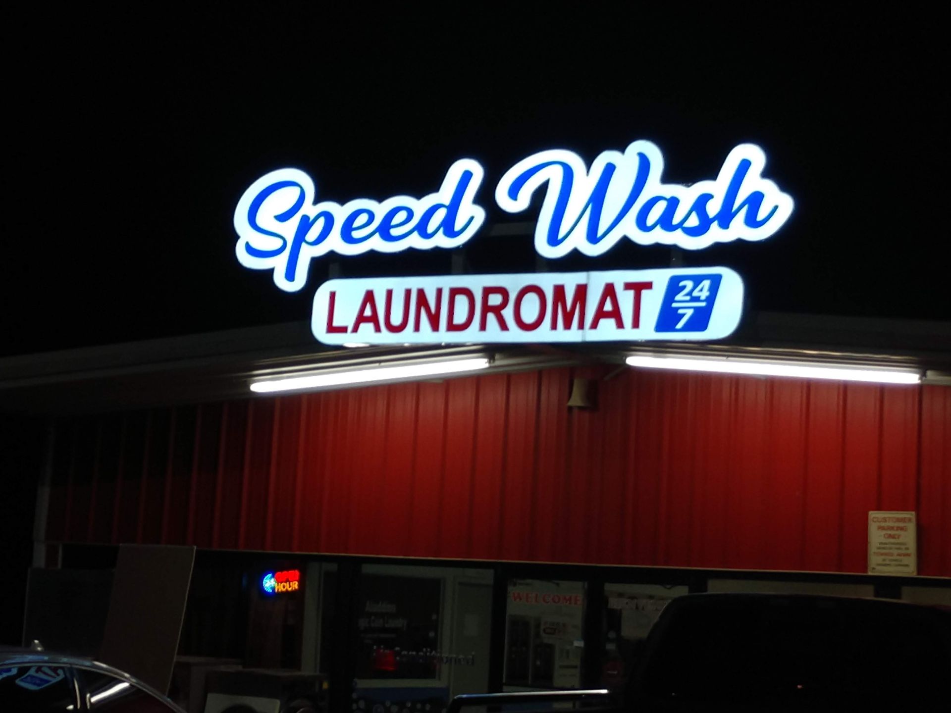 A speed wash laundromat is lit up at night