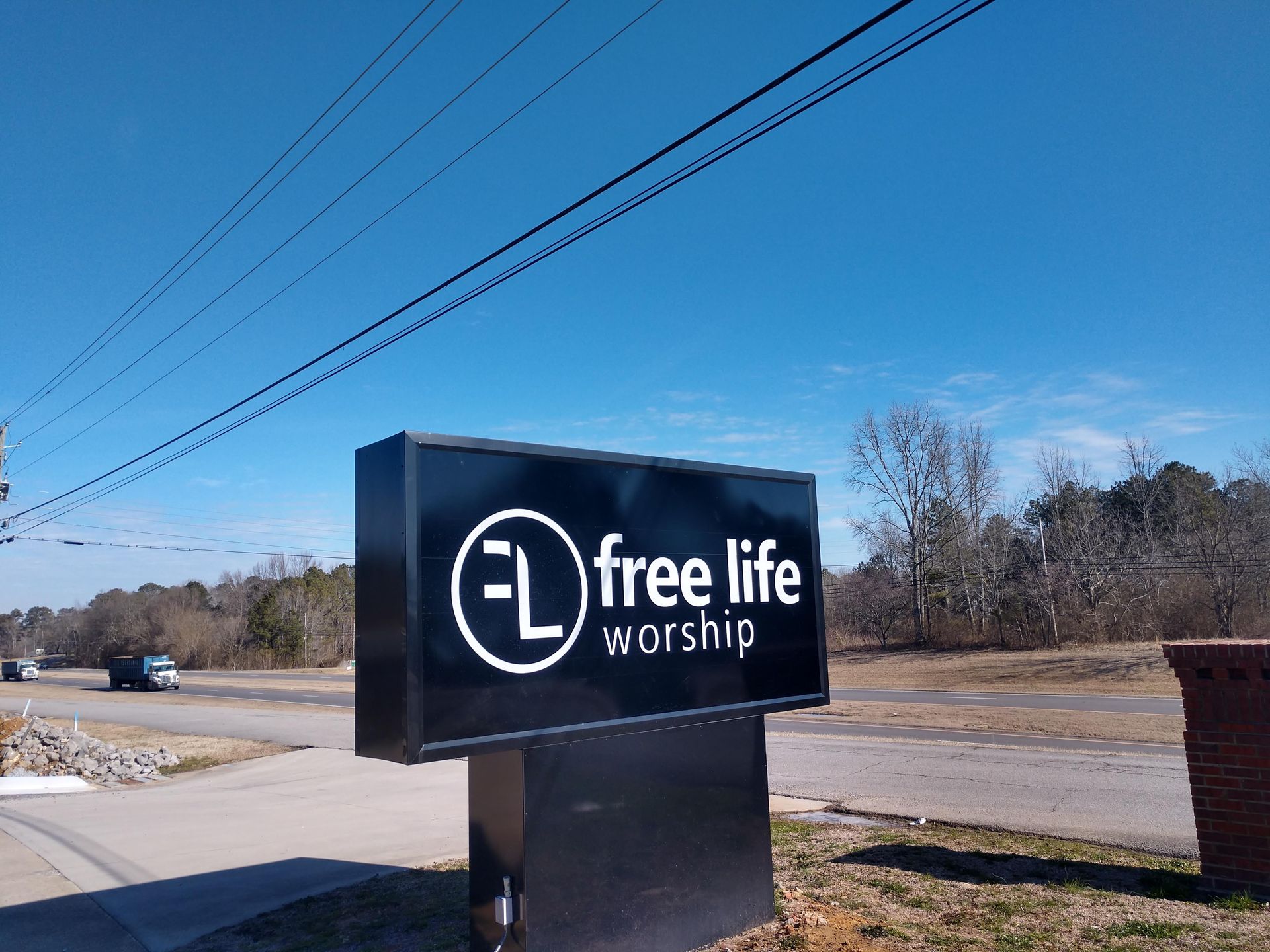 A black sign that says free life worship on it