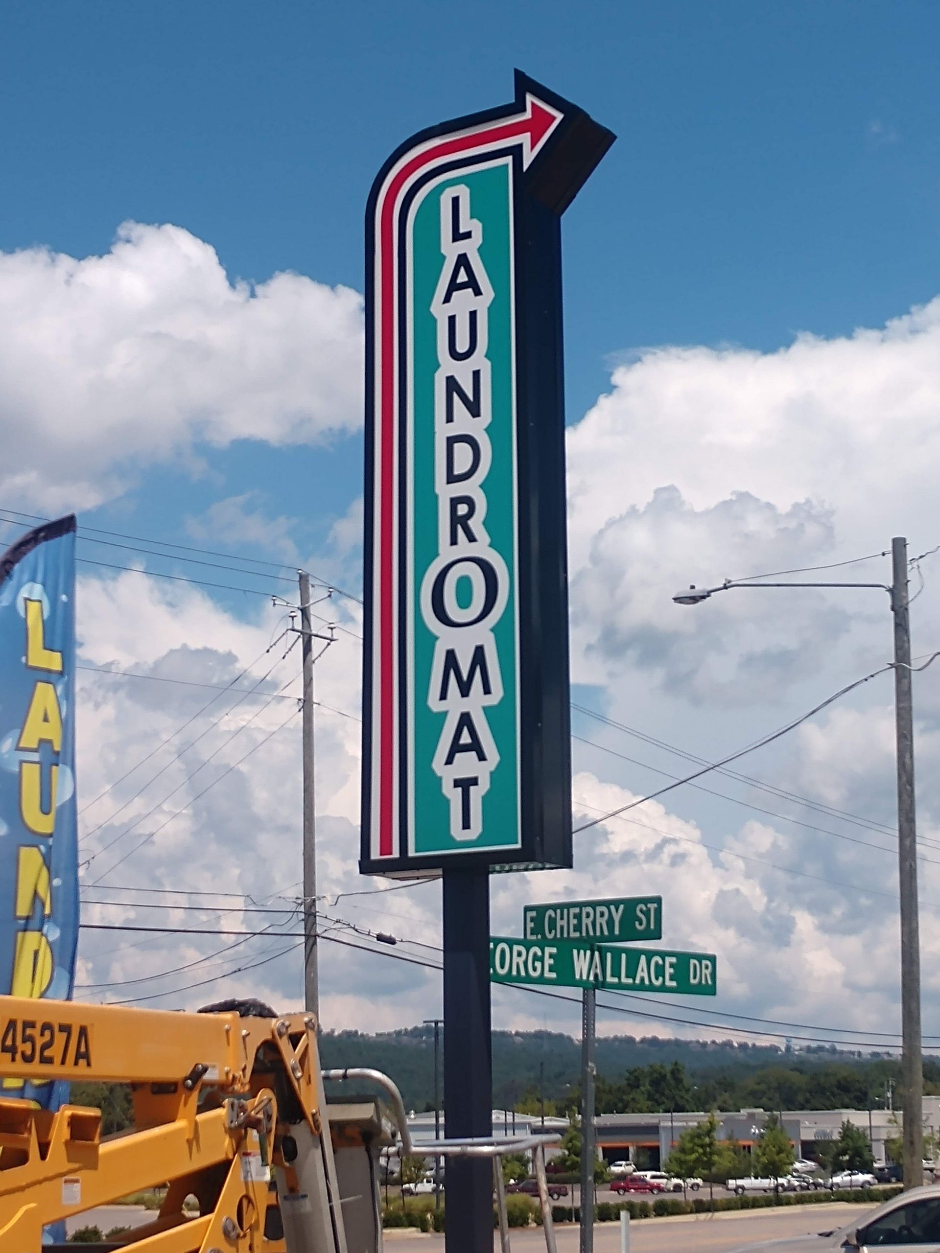 A sign for a laundromat with an arrow pointing to the right