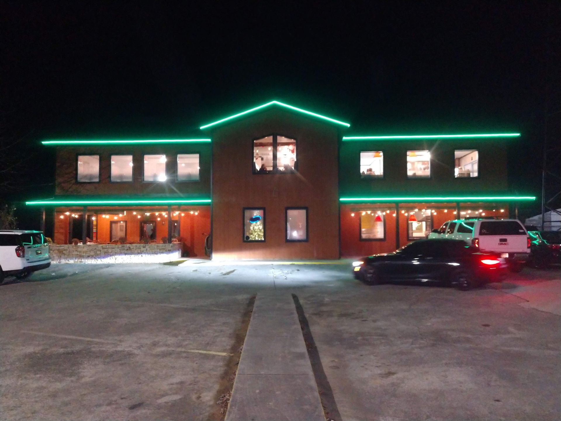 A large building with green lights on it is lit up at night