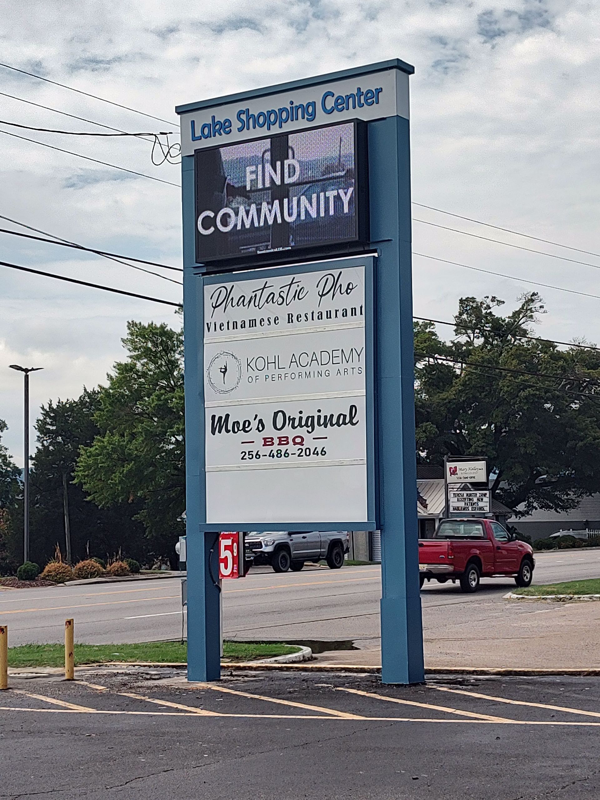 A lake shopping center sign in a parking lot