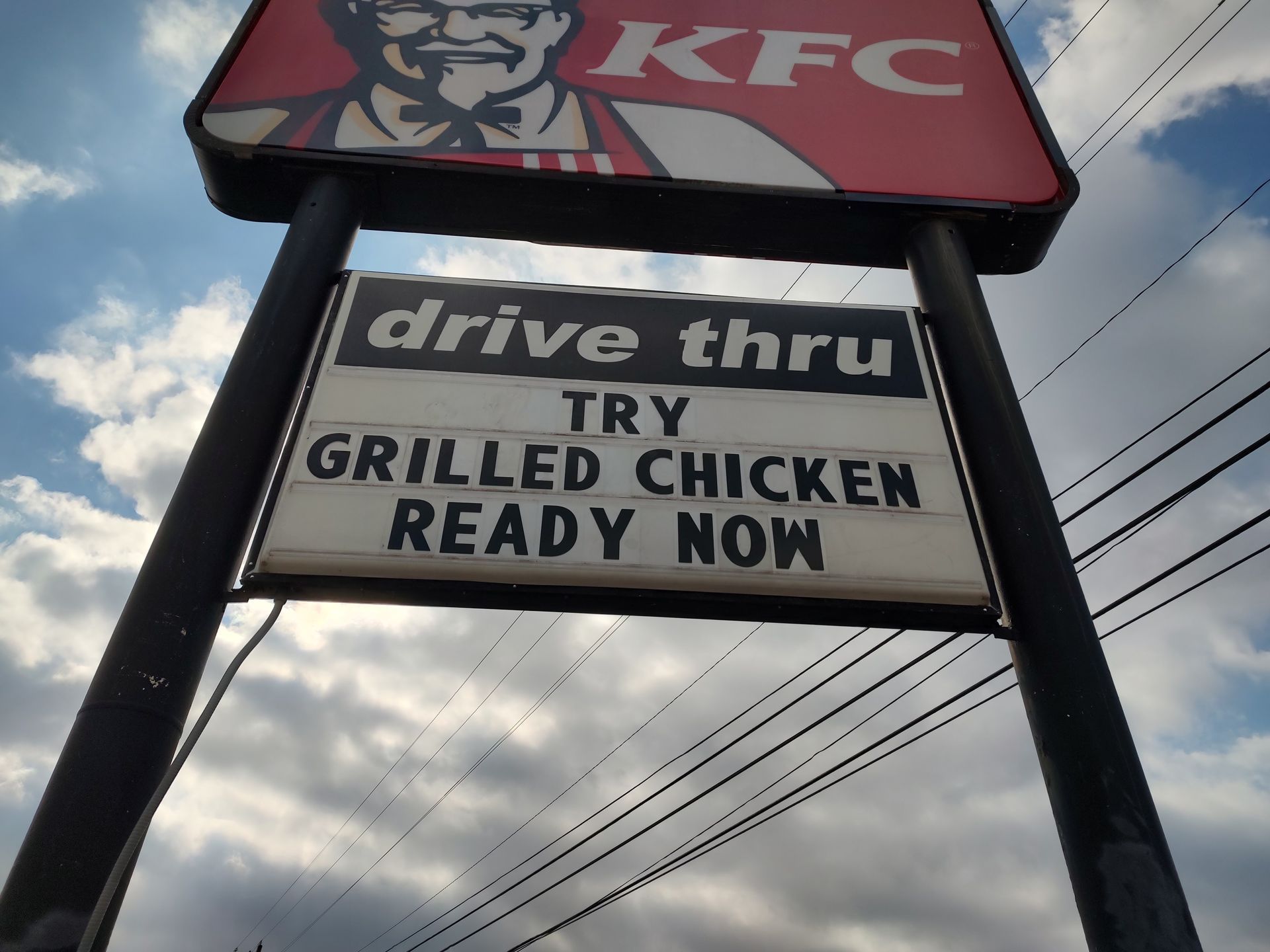 A kfc sign that says drive thru try grilled chicken ready now