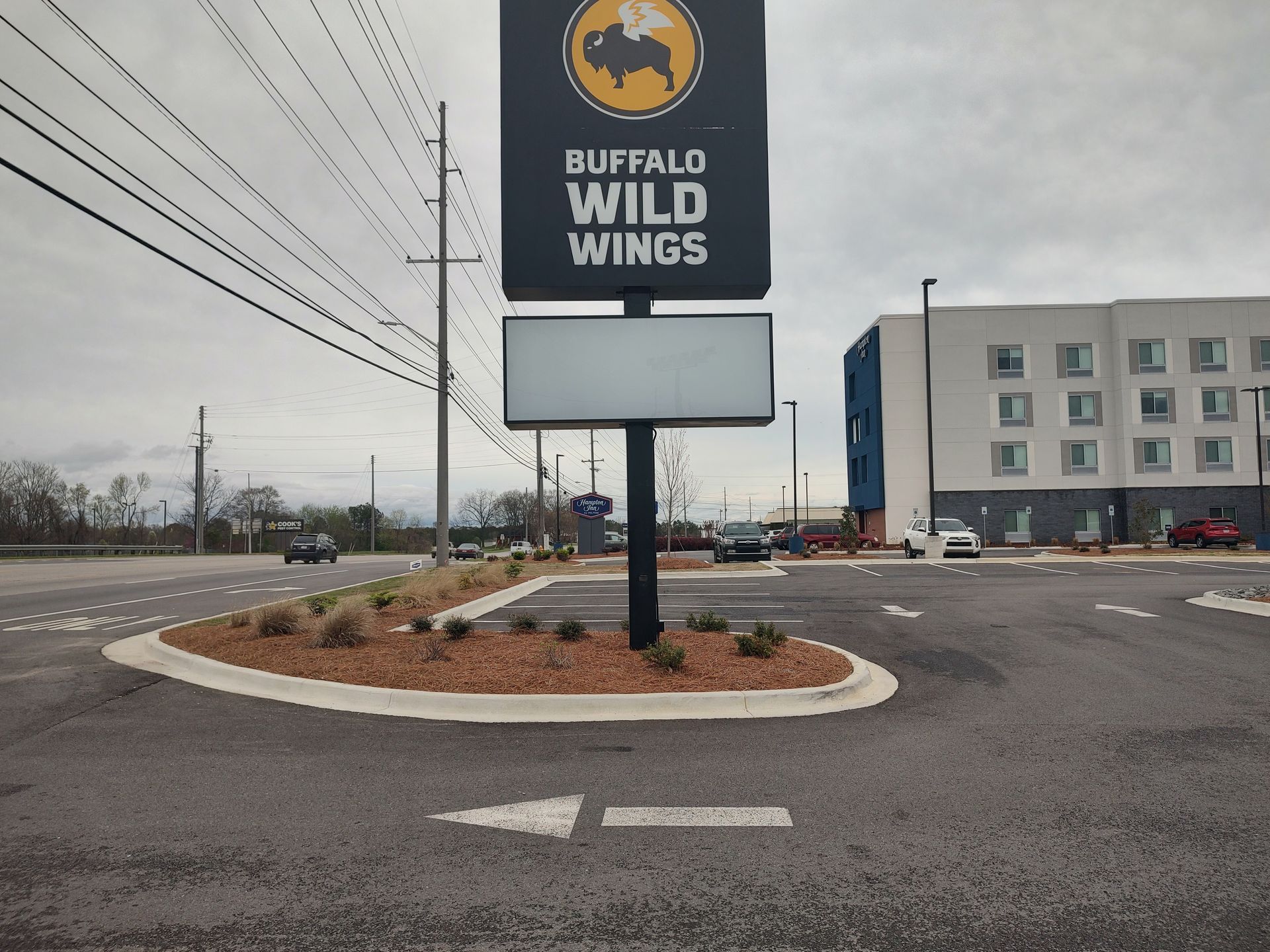 A buffalo wild wings sign is in the middle of a parking lot.