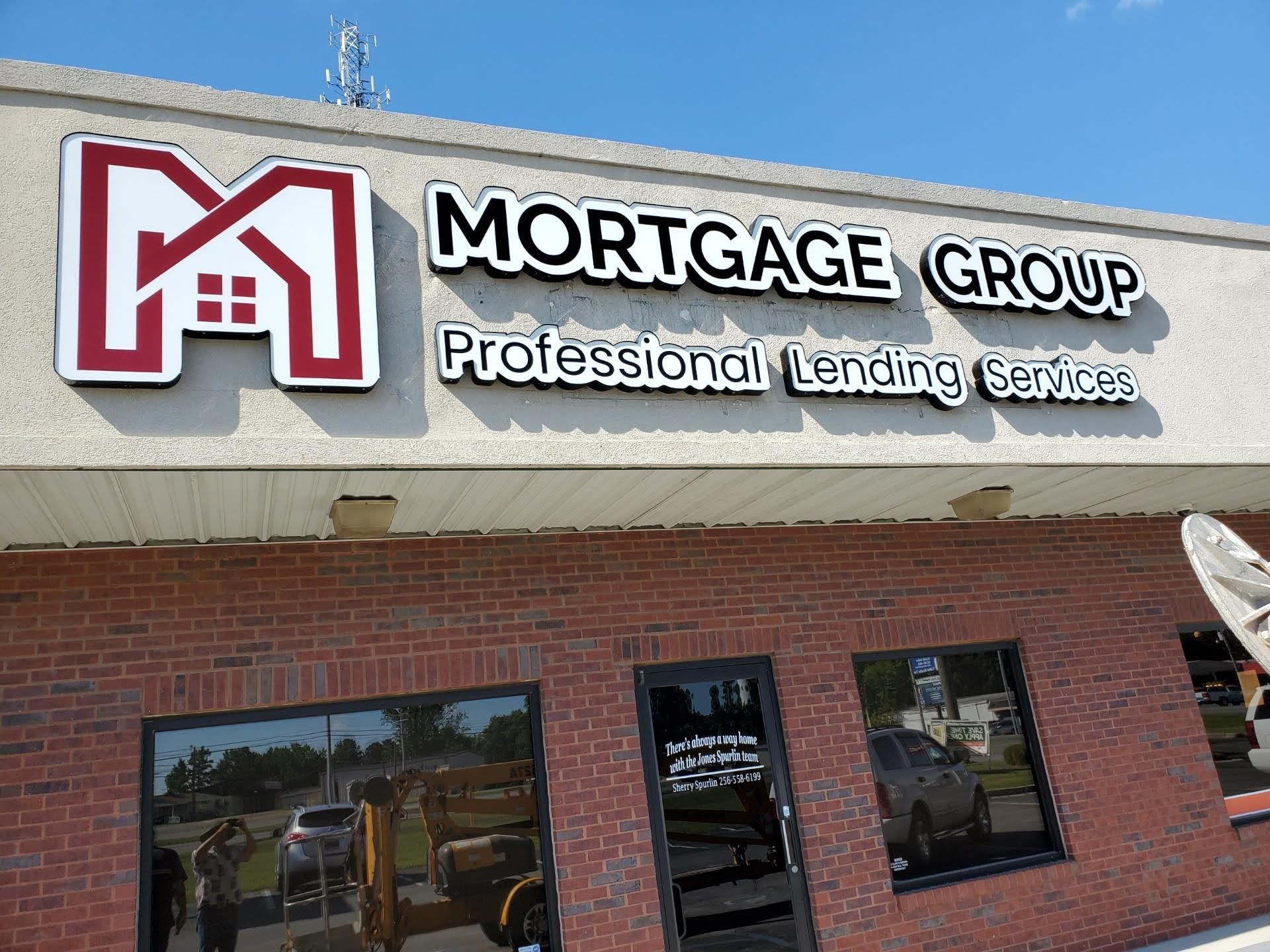 A brick building with a sign that says mortgage group professional lending services