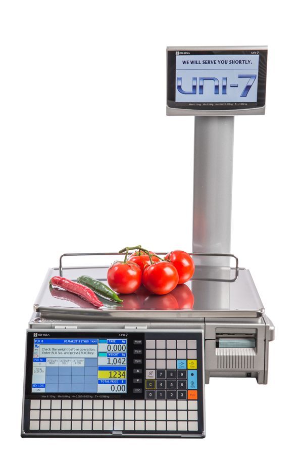 Digital scale with tomatoes and peppers; displays weight and price on a screen.
