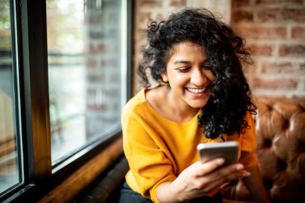 Girl in yellow shirt texting on phone