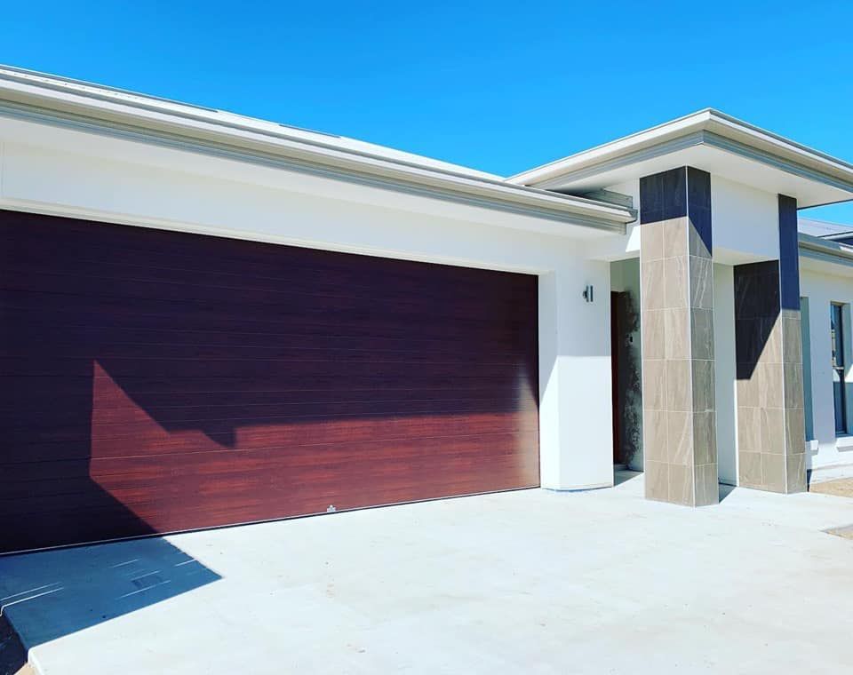 A large white house with a brown garage door