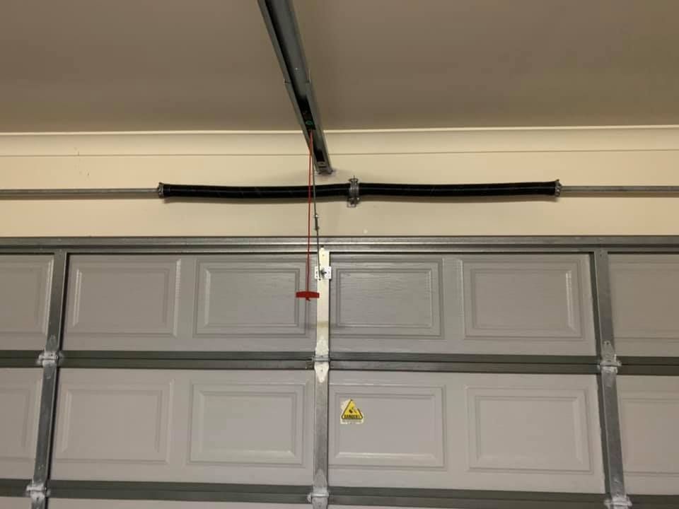 A garage door with a spring hanging from the ceiling.