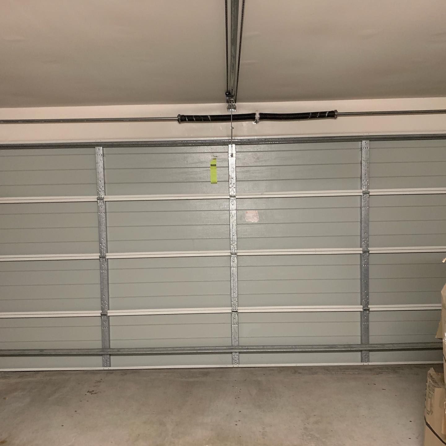 A garage door is open and empty in a garage.