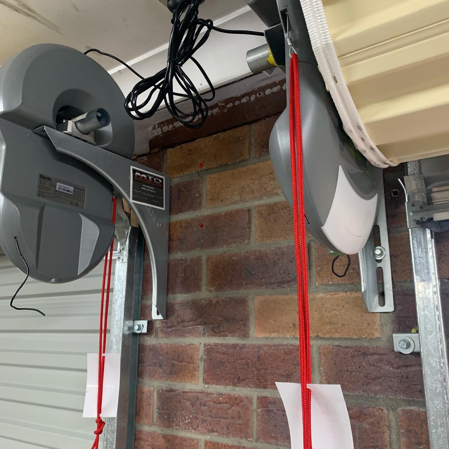 A garage door opener is attached to a brick wall