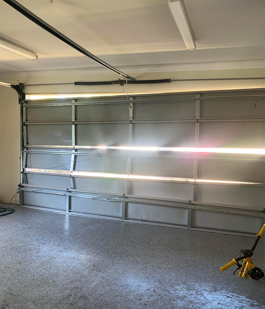 A garage door is open and the light is shining through it.