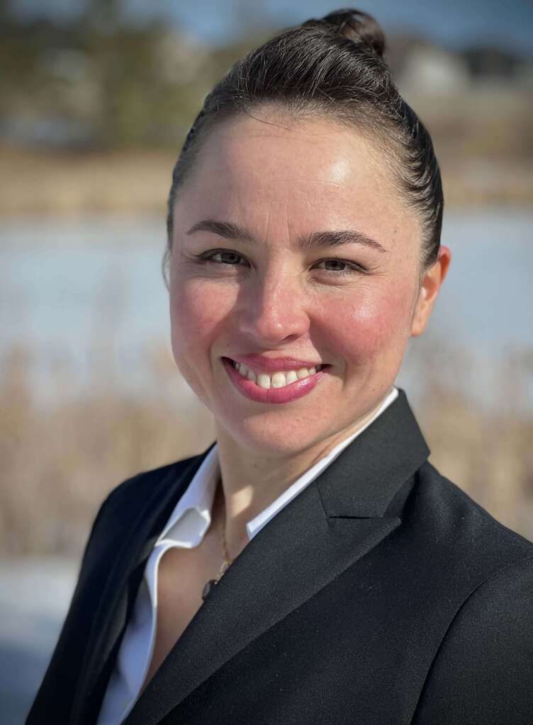 A woman in a blazer smiling at the camera.