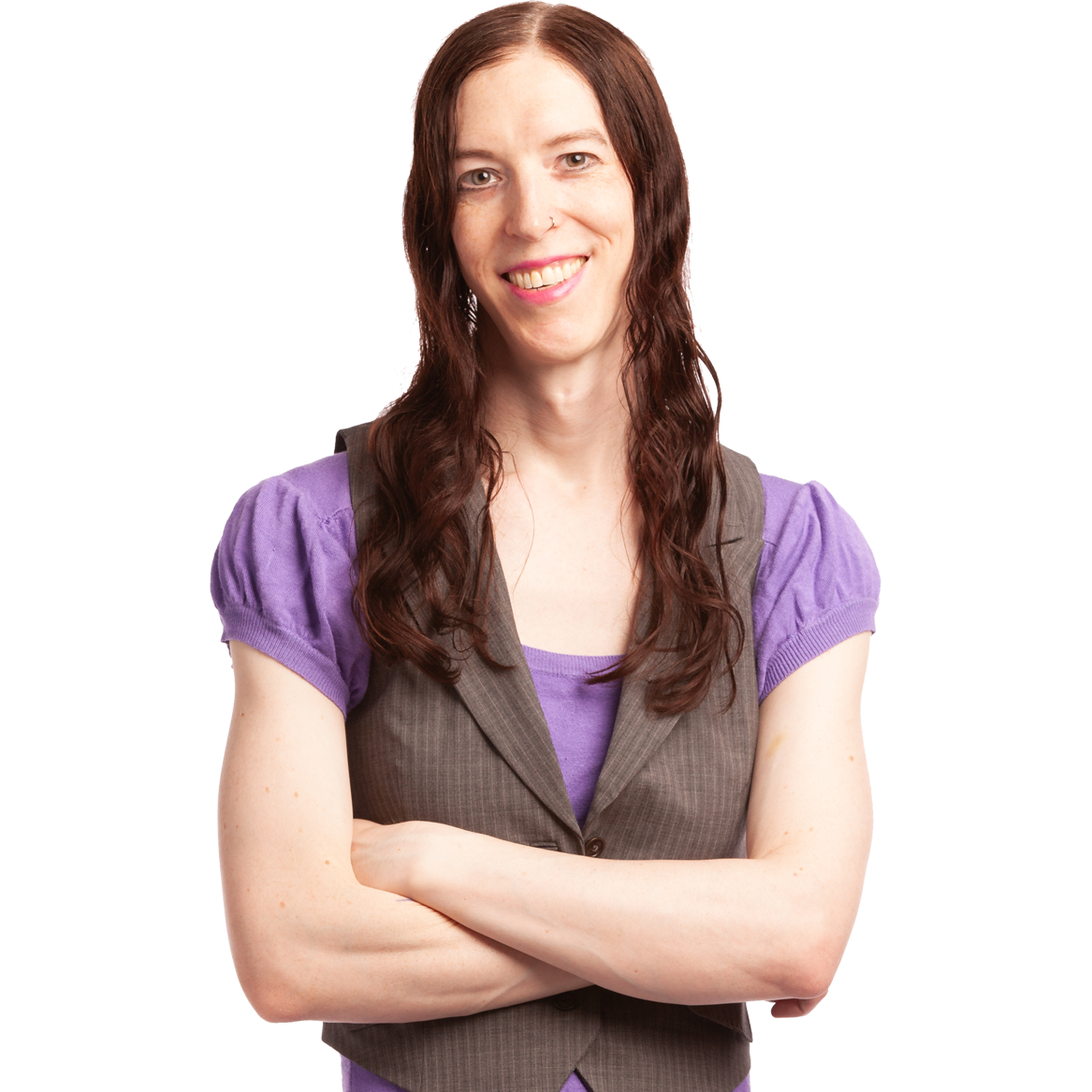 Smiling person with long dark hair, arms crossed, wearing a purple top and gray vest on a white background