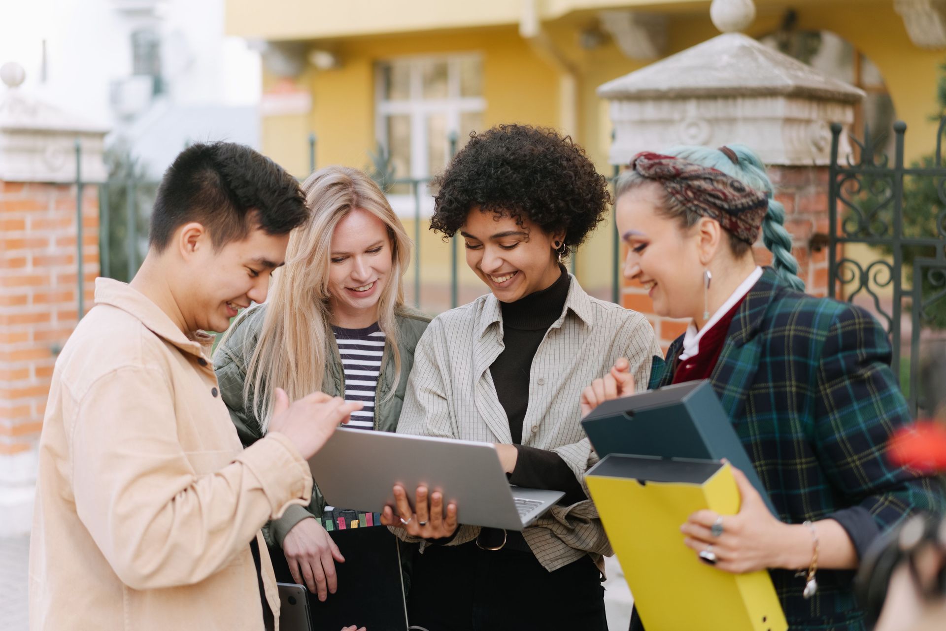 A group of young people are looking at a laptop computer.