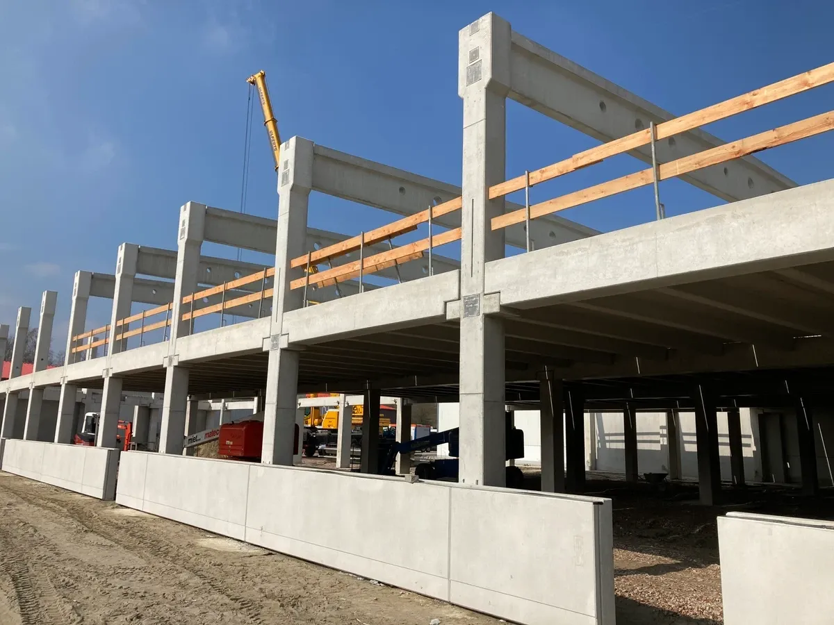 Ein großes, im Bau befindliches Betongebäude mit einem Holzgeländer.