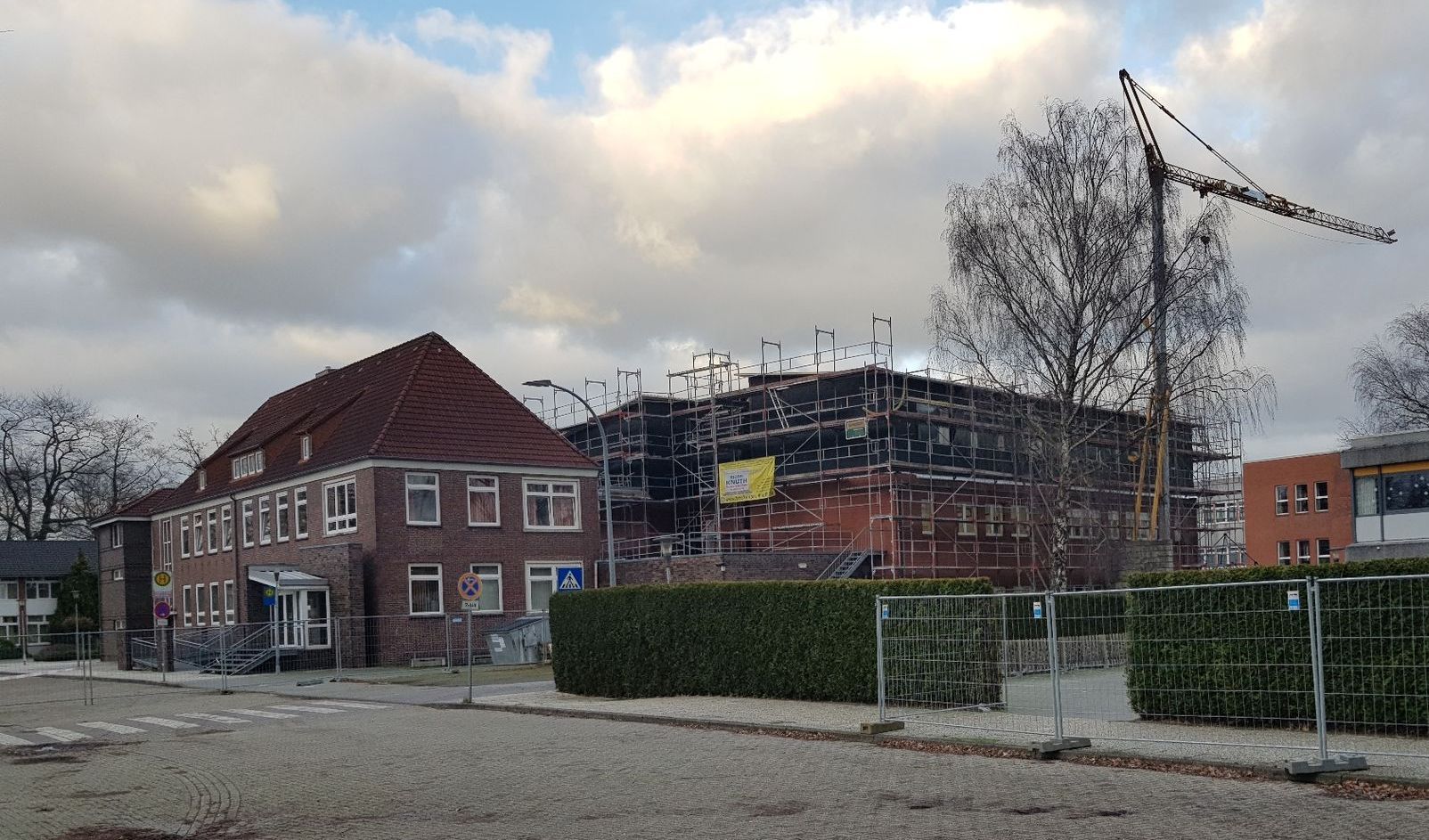 Neben einem kleineren Gebäude wird ein großes Gebäude errichtet.