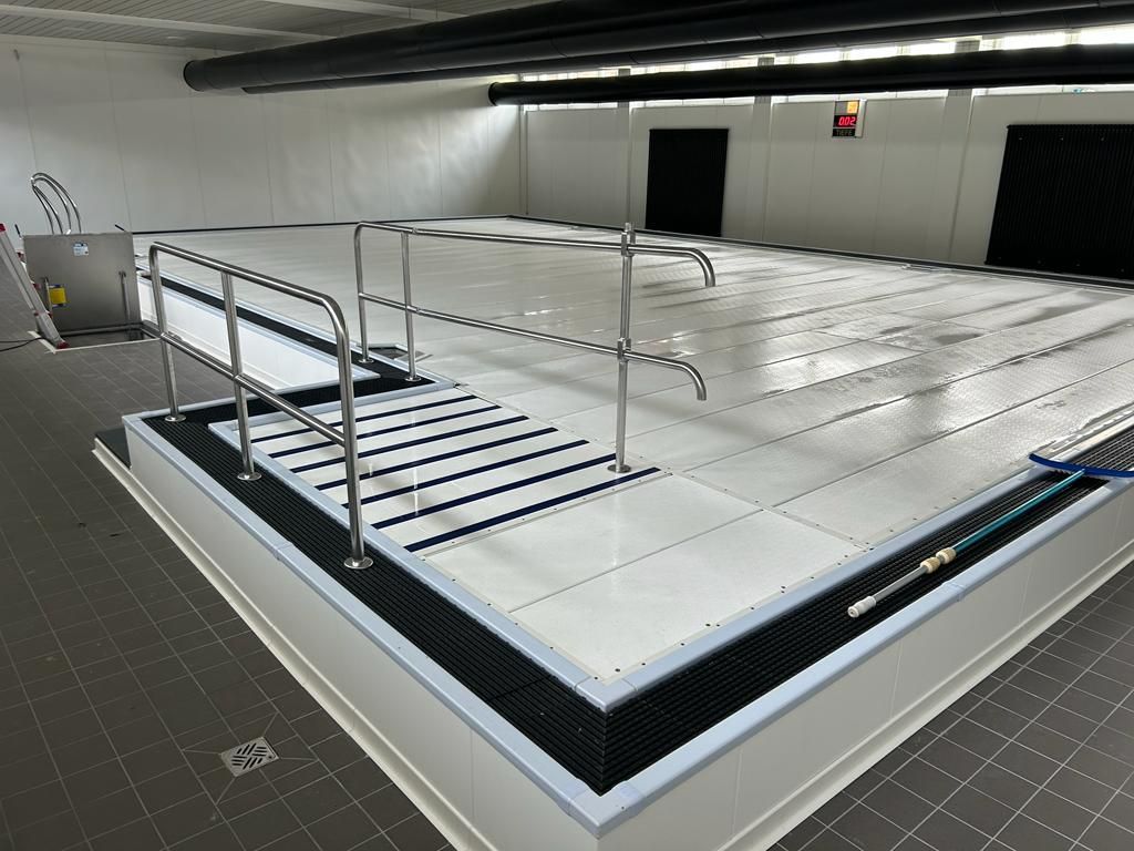 Ein großes Hallenbad mit Treppe und Geländer