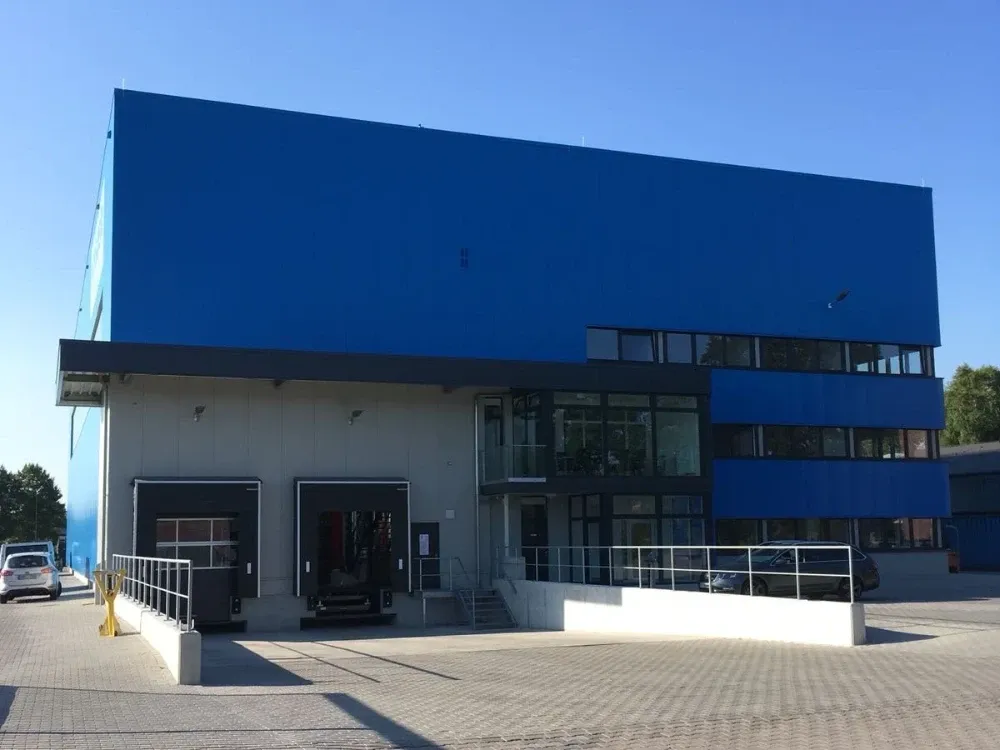 Ein großes blau-weißes Gebäude mit einer Laderampe davor