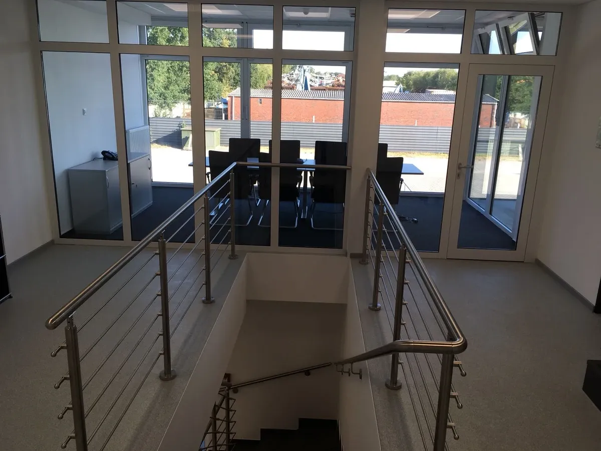 Treppe führt zu einem Konferenzraum mit Tisch und Stühlen