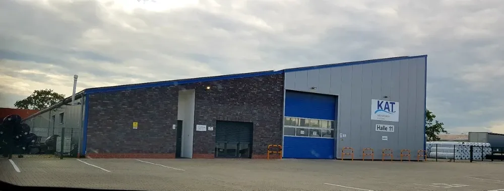 Ein großes Gebäude mit einer blauen Tür und einem Schild mit der Aufschrift „Kat“ darauf.