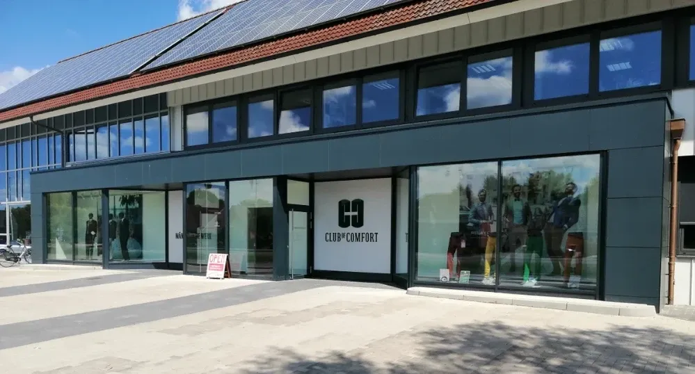 Ein großes Gebäude mit vielen Fenstern und Solarzellen auf dem Dach.